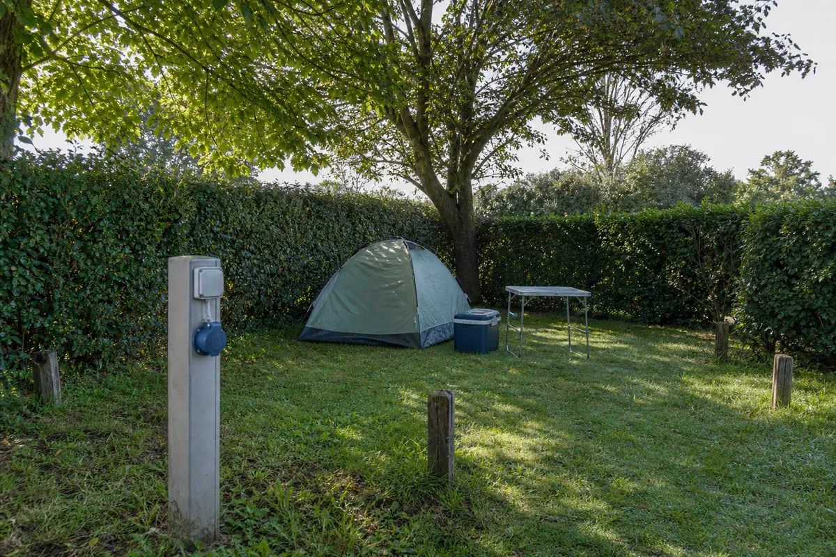 Emplacement nu avec tente et borne électrique en camping